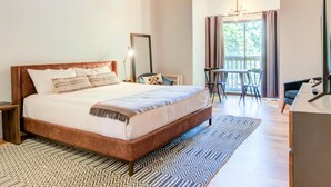 A bedroom with a large bed, a desk, and a chair near a window. - Mountain Inn Studio 96 with Wintergreen Advantage (Wintergreen)
