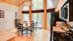 Une cuisine spacieuse dotée de planchers en bois, de grandes fenêtres et d’appareils électroménagers modernes.