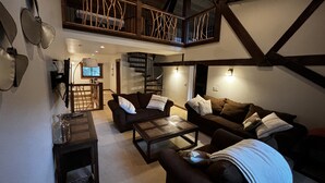 A spacious living area with a high ceiling, a staircase, and a television. - Luxury condo perfectly located in Cavanaugh Bay! Fully furnished!  (Coolin)