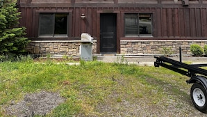 A two-story log cabin with a stone foundation, large windows, and a metal roof. - Luxury condo perfectly located in Cavanaugh Bay! Fully furnished!  (Coolin)