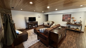 A cozy living room with a brown leather sofa, a wooden coffee table, and a television on a wooden cabinet. - Luxury condo perfectly located in Cavanaugh Bay! Fully furnished!  (Coolin)