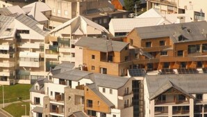 A residential area with multi-story buildings, some with visible balconies and solar panels.