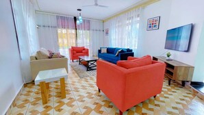 Un salon avec un canapé, une table basse et un téléviseur.