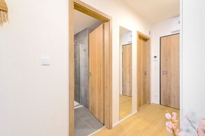 Un couloir avec des portes en bois et un espace douche.