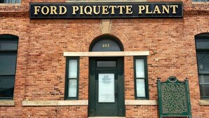 A brick building with a sign reading 'FORD PIQUETTE PLANT' and a plaque with historical information. - Spacious Detroit Retreat • Sleeps 16 • Parking (Detroit)