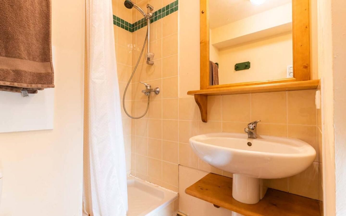 A bathroom with a bathtub, a shower, a sink, and a mirror.