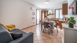 A modern apartment with a dining area, kitchen, and living room.