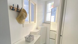 A small, white bathroom with a vanity, a mirror, and a patterned floor. - Arime Apartment
Elegance and Tradition a Stone's Throw from the Sea" (Lacco Ameno)