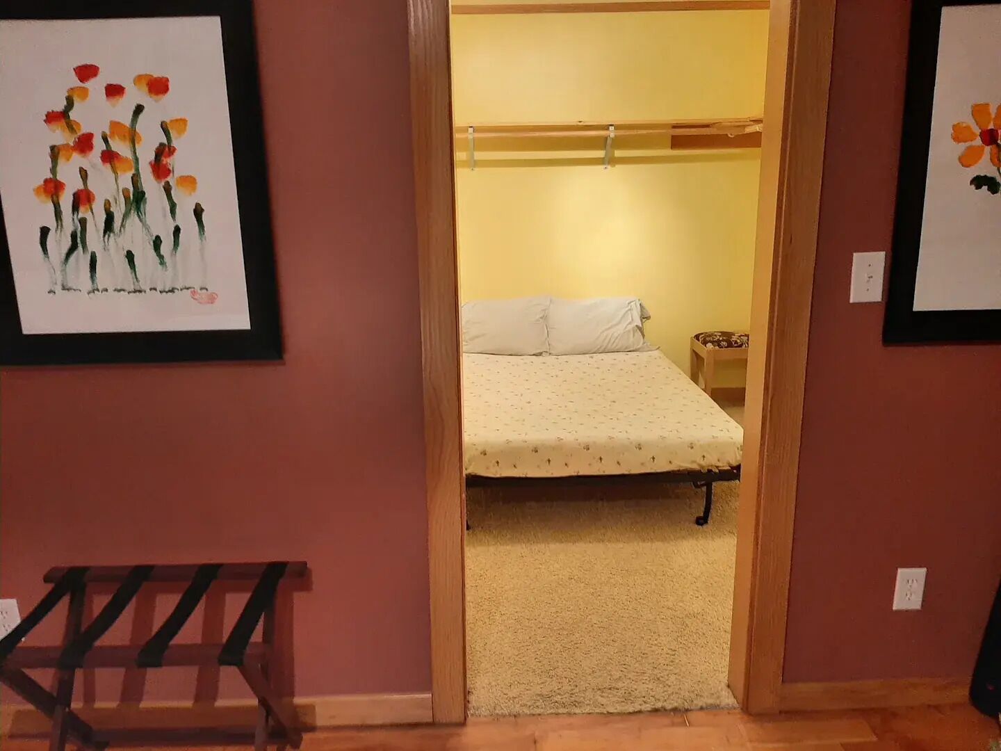A bedroom with a bed, a nightstand, and a wooden bench.