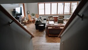 A spacious living room with a staircase leading to a lower level.