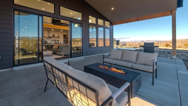 A modern outdoor living area with a fire pit, seating, and a view of the landscape. - The Grove-River Cabin -Hot Tub- Family Home Near Bryce & Zion (Hatch)
