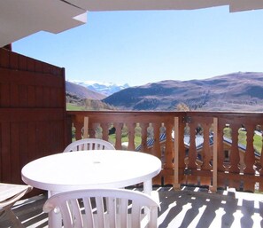 A balcony with a view of mountains, a white table, and white chairs. - 100m from ski slopes, 5th floor, tv, ski locker, 30m², Alpe d'Huez (L'Alpe d'Huez)