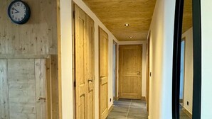 A hallway with wooden doors, a clock, and a large mirror. - 2nd floor, view mountain, balcony, tv, 81m², La Plagne (Aime)