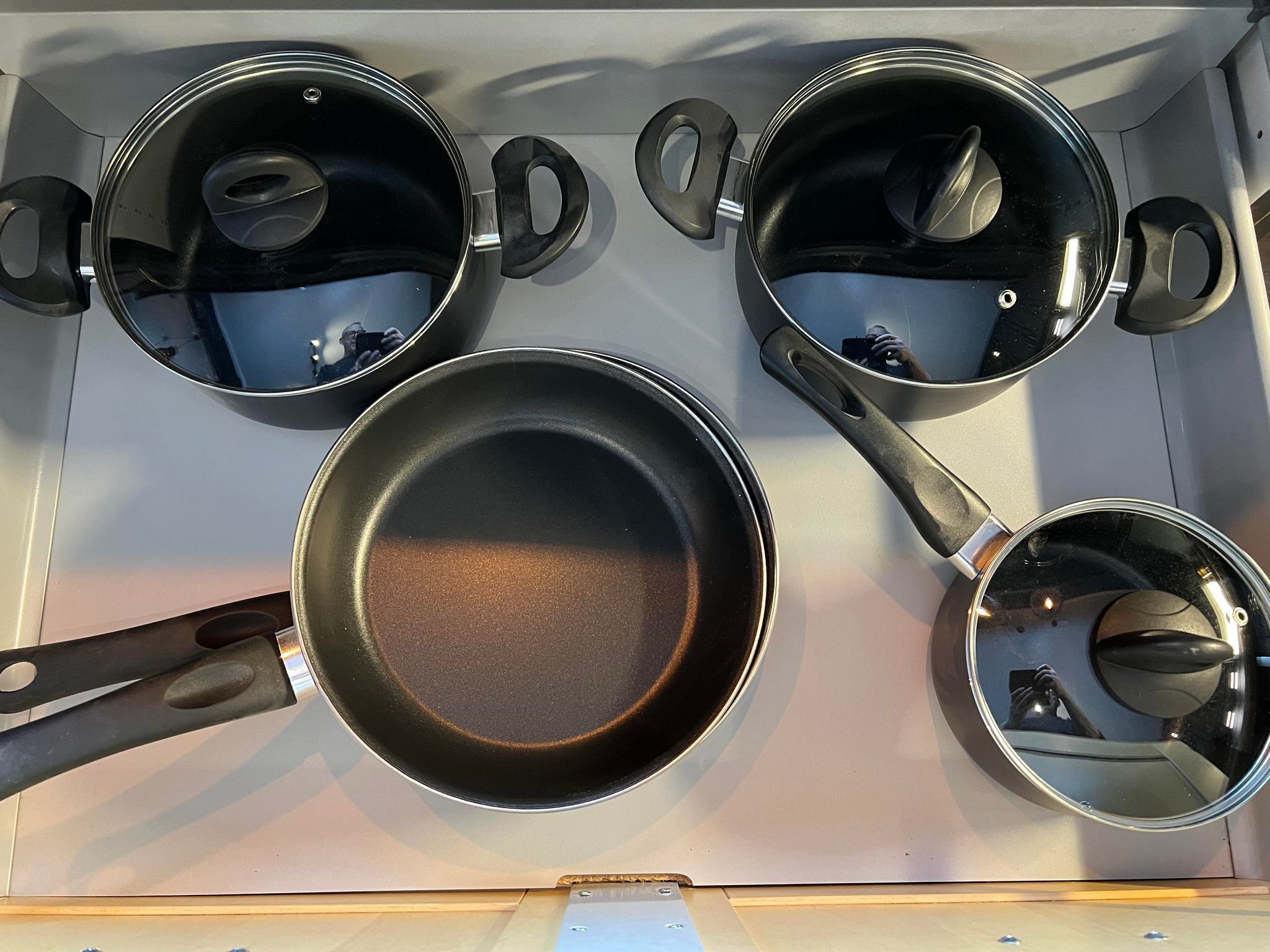 A kitchen with four pots and pans on a stove.