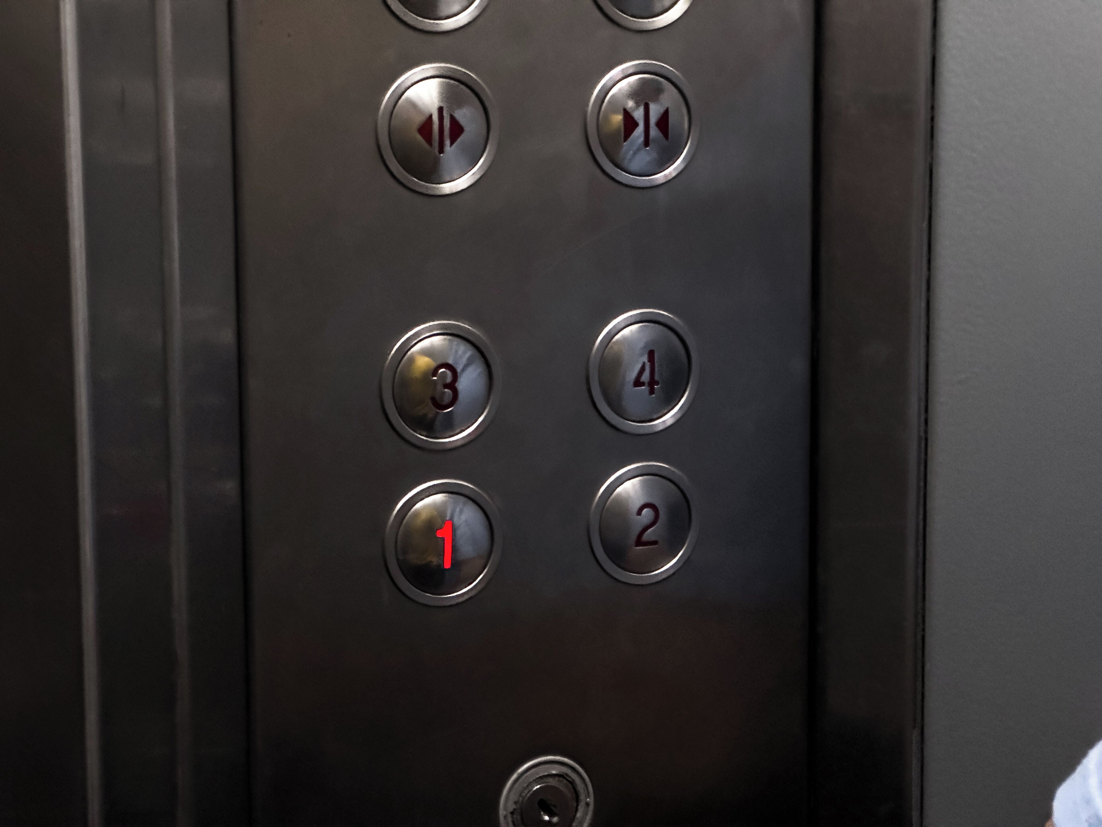 An elevator control panel with buttons numbered 1 to 4 and directional arrows.