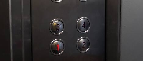 An elevator control panel with buttons numbered 1 to 4 and directional arrows.