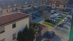 A residential area with multiple apartment buildings, a parking lot, and a street with cars.