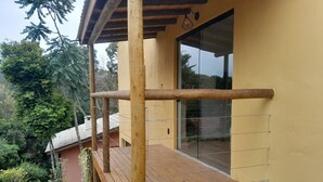 Una terraza de madera con un ventanal de vidrio que da a una habitación.