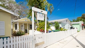 A white picket fence, a sign with a house number, and a building with a porch. - Prime Downtown Key West Spot - The Cozy Little Cottage! (Key West)