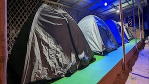 A row of covered tents with a metal roof structure and a green floor. - Resort Ichche Kuthi by Urban Express (Bangaon)
