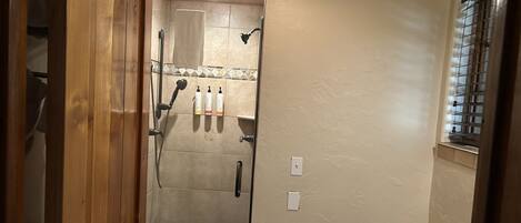A bathroom with a glass shower door, a toilet, and a sink.