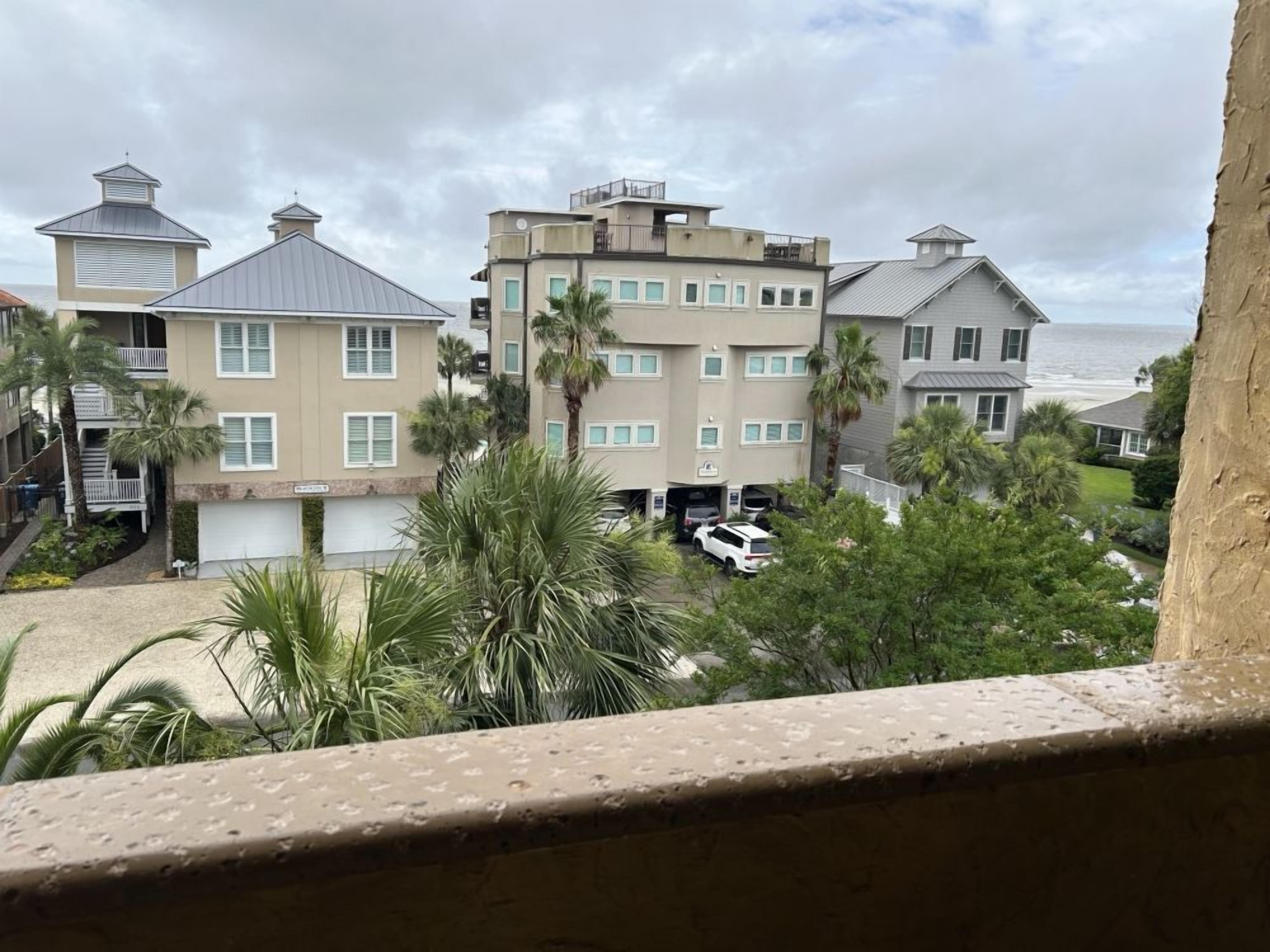Un quartier résidentiel situé sur la côte, composé de plusieurs immeubles à deux étages, dont certains sont dotés de balcons, et offrant une vue sur l’océan.
