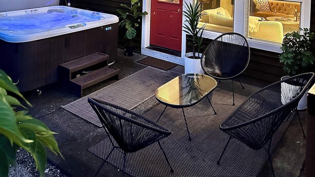 A house with a hot tub, outdoor seating, and string lights.