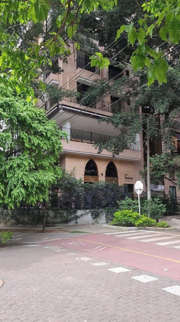 A multi-story building with a brick facade, arched windows, and balconies.