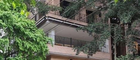 A multi-story building with a brick facade, arched windows, and balconies.