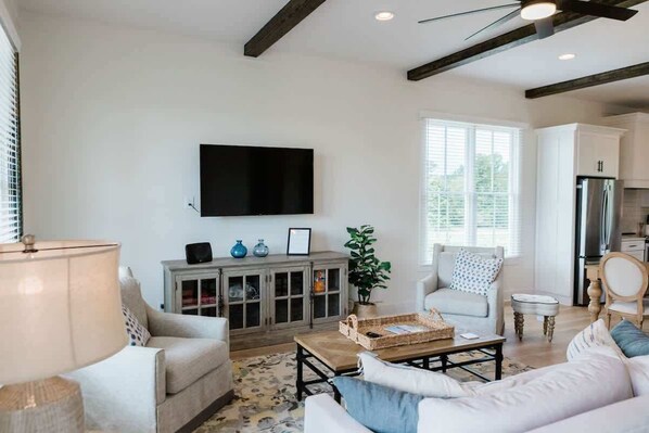 A living room with a sofa, a coffee table, a television, and a cabinet.