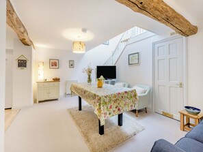 A cozy room with a table, chairs, a TV, and a staircase. - 5 bedroom accommodation in Slapton (Slapton)