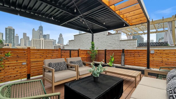 A rooftop patio with outdoor seating, a black table, and a city skyline view. - 6BD/5BTH + Roofdeck - Downtown Chicago! (Chicago)