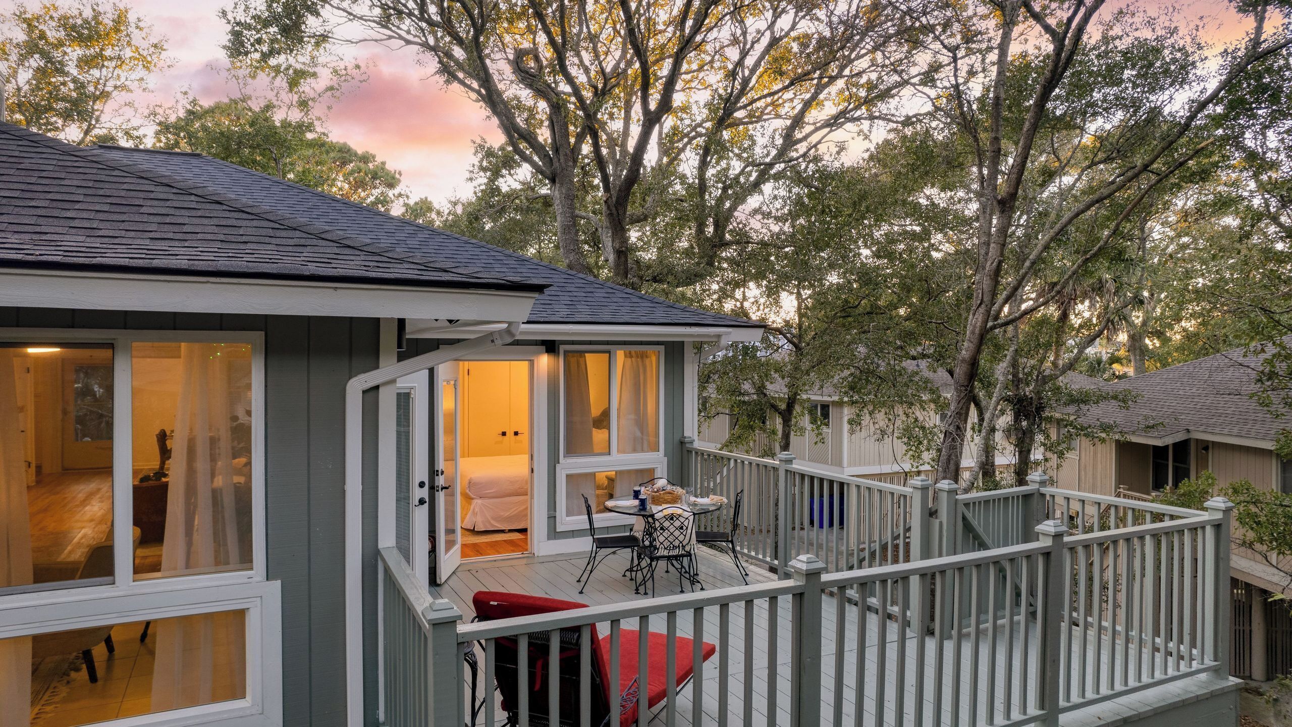 A two-story house with a balcony, a bed, and a dining table.