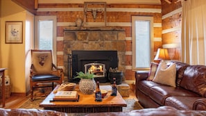 A cozy log cabin interior with a stone fireplace, leather furniture, and rustic decor. - Twilight Ridge by Avantstay Mountain Mansion, 20min to Pigeon Forge (Sevierville)