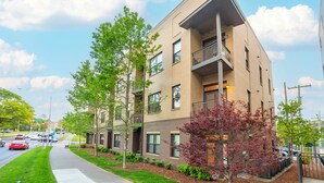 A multi-story building with a flat roof, large windows, and a balcony on the second floor. - Music Row w Free Parking  Close to University (Nashville)