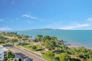A coastal hotel with a view of the sea, a beach, and a pier.