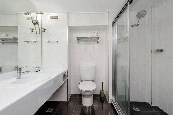 A modern bathroom with a large bathtub, a toilet, and a glass-enclosed shower area. - Studio 503 - Prime Spot With Oceanviews (North Ward)
