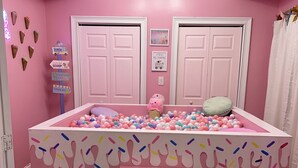 A pink-themed room with a ball pit, a ceiling light fixture, and a door with a frosted glass panel. - GIRLS SUITE w/ BALL PIT! 3 THEMED BEDROOMS & 2 BATH located in CHINATOWN  (Philadelphia)
