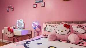 A pink-themed bedroom with a bed featuring Hello Kitty designs, a desk with a Hello Kitty mirror, and Hello Kitty pillows. - GIRLS SUITE w/ BALL PIT! 3 THEMED BEDROOMS & 2 BATH located in CHINATOWN  (Philadelphia)