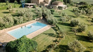 A large swimming pool surrounded by lush greenery and a historic building with a tower. - Villa Stellina - Private Tuscan villa with pool (Tavarnelle Val di Pesa)