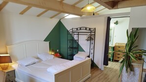 Een slaapkamer met een bed, een bedlampje en een hanglamp.