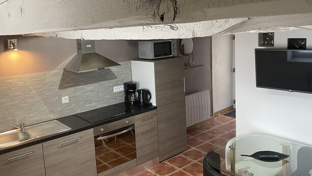 A compact kitchen with a microwave, coffee maker, and a small refrigerator.