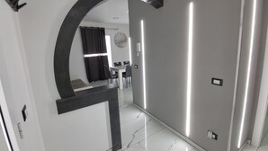 Ein modernes Interieur mit einem gewölbten Spiegel, einem Essbereich und einem Badezimmer mit Dusche.