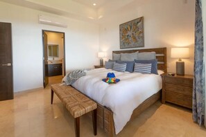 Een moderne slaapkamer met een groot bed, een houten hoofdbord, bedlampen en een bankje.