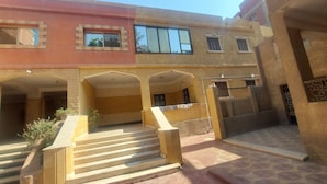 Un edificio de varios pisos con un patio central, que presenta una escalera que conduce a un nivel superior.