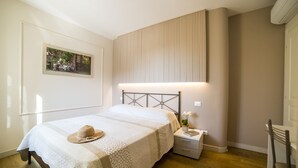 A bedroom with a bed, nightstand, and a wall-mounted light fixture.