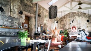 Un intérieur rustique avec des murs en pierre apparentes, un bar en bois et un cheval de carrousel.