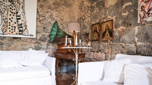 Une pièce avec un mur en pierre, une table décorée de bougies et un tableau religieux encadré.