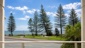 A balcony with a view of a road, trees, and the ocean. - Bellardoo 12 Beach View Mooloolaba (Mooloolaba)