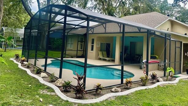 A house with a swimming pool, covered patio, and a fenced area. - Charming , 2 bedroom , 1 bath  (Kissimmee)